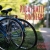 [Image Description:  A photo of two bicycles, standing side-by side, next to a wooded path. The image is cropped so that only the seat and back tires of the bicycles are visible. Superimposed text reads, “Koda Family Fun Night, KODAheart #k3famILY.”]