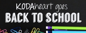 White text hovers over colorful school supplies, including paper clips and mechanical pencils. The text reads: "KODAheart goes Back to School"