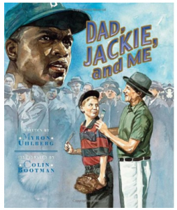 Image description: “Dad jackie and me” is the title of this book showing a group of people in 1970’s clothing and a young boy wearing a baseball mit. In the upper left hand of the photo a portrait of a Black man wearing a baseball cap sits behind the crowd of men in top hats.