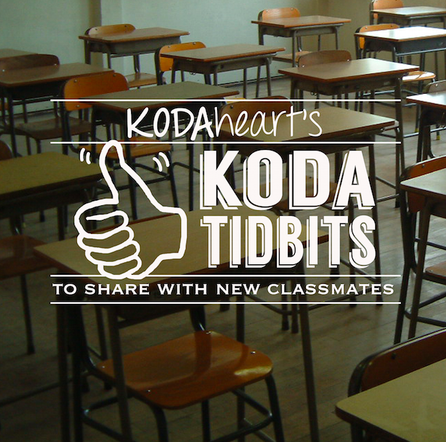 Image Description: A thumb, outlined in white, signs “10” with accompanying text that reads: “KODAheart’s [10] Tidbits to share with new classmates" The background image is an angled photo of a classroom full of desks.