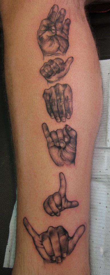 [Image description: Tattoo of ASL fingerspelling F-A-M-I-L-Y beginning at the top of the calf part of a white leg. Each hand forming the ASL letters is different stacked one on top of the other down the calf.]