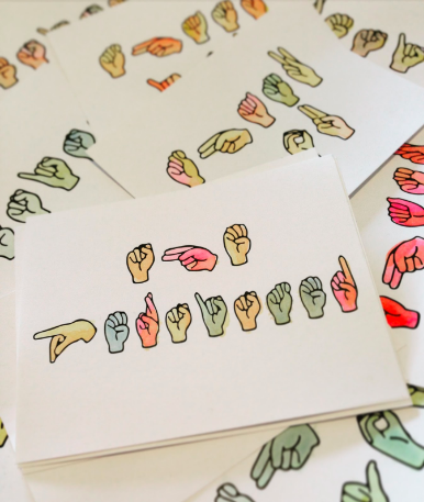 [Image description: Postcards with various words spelled out in American Sign Language are stacked on top of one another. The handshapes are filled in with watercolors]