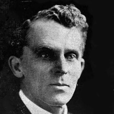 Image Description: A black and white portrait of a clean-shaven white man in a suit and tie.